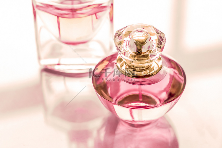 粉红色香水瓶在光滑的背景、甜美