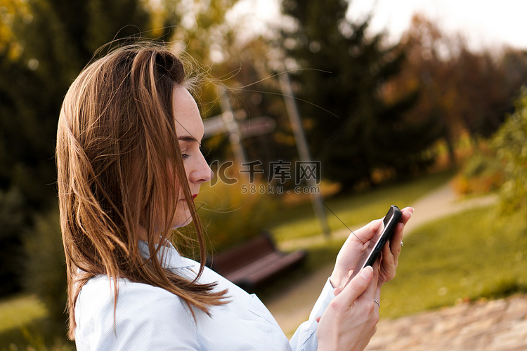 在公园里使用智能手机的女人