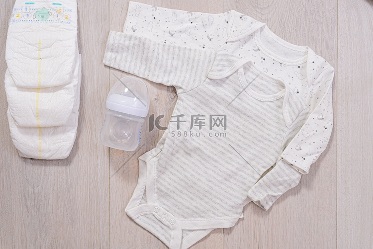白色婴儿衣服、尿布和婴儿奶瓶木