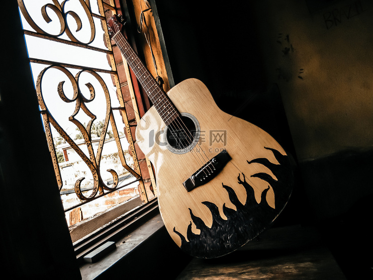 一把原声吉他放在旧的复古窗户旁