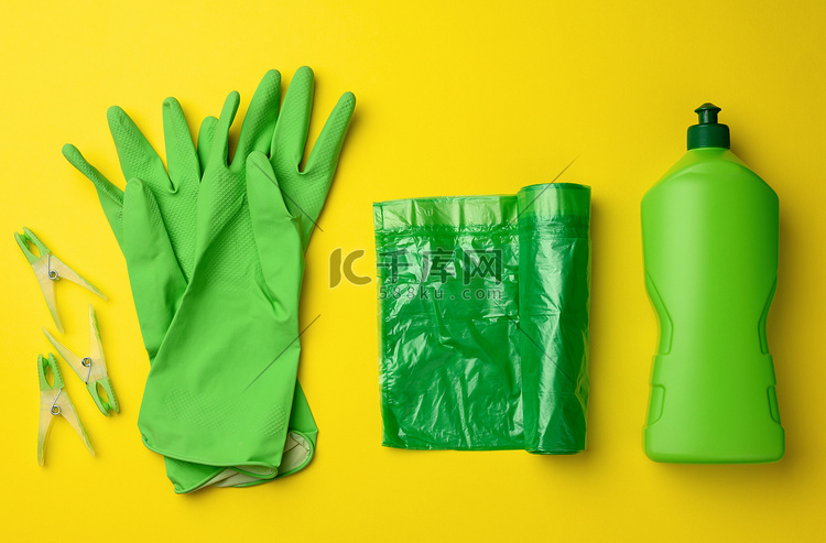 黄色背景清洁用橡胶绿手套、垃圾