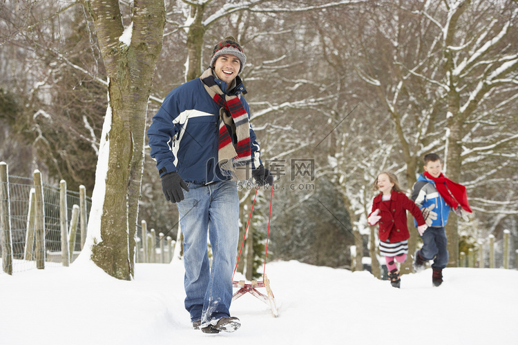 父亲拉着孩子们乘坐雪橇穿越冬季