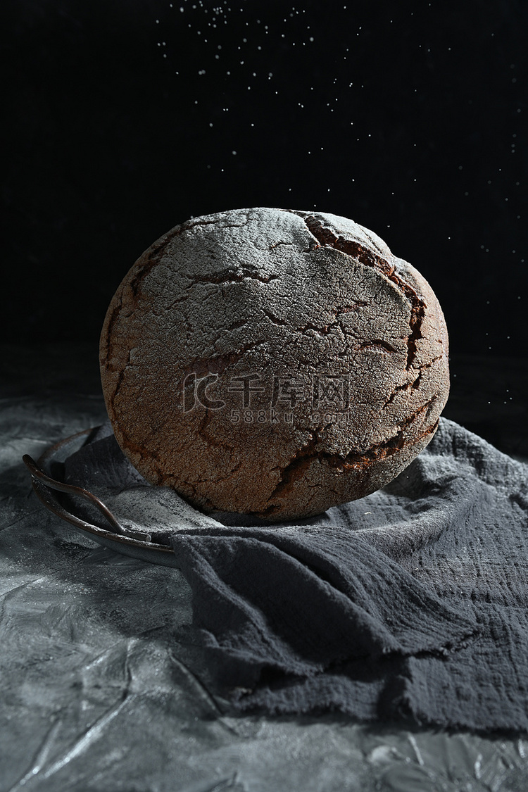 黑暗的空间和灰色桌子上的新鲜黑面包