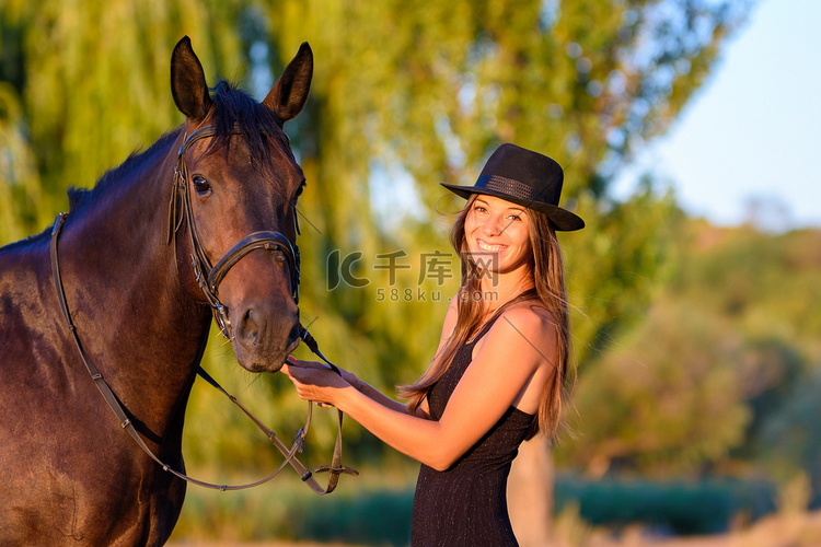 戴着帽子的快乐女孩和一匹马在温