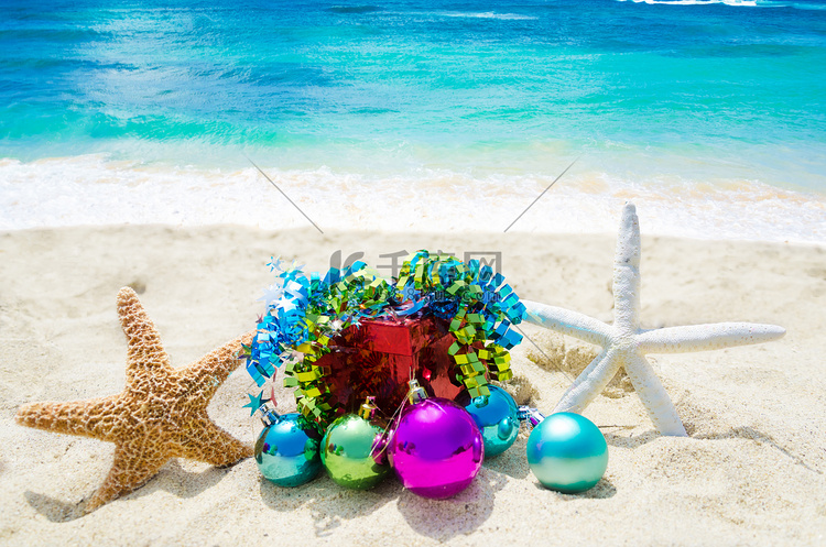 沙滩上有两只带圣诞球和礼物的海