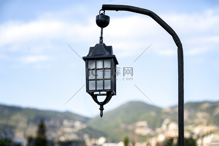 一盏旧路灯挂在一根杆子上。