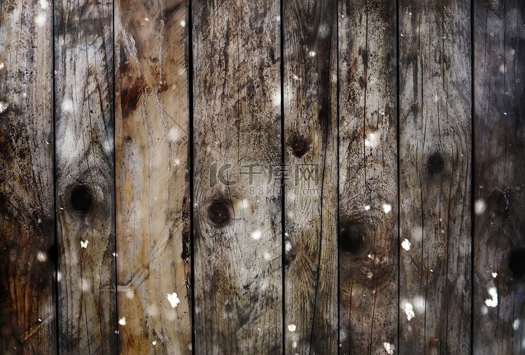 具有雪和闪光散景效果的木板背景