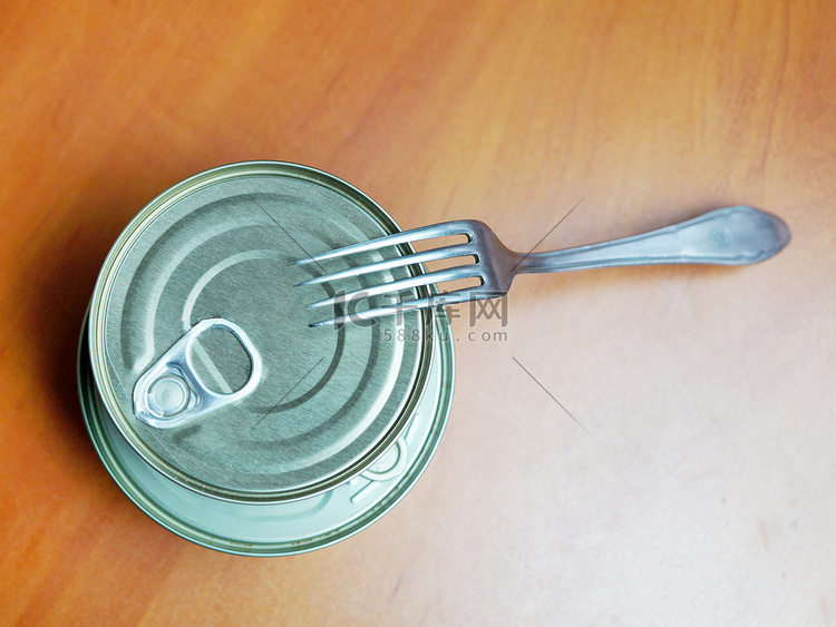 木桌上封闭的锡罐和叉子