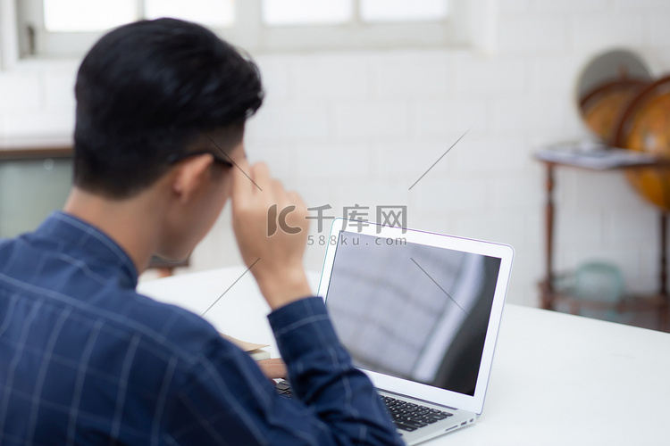 年轻的亚洲商人使用笔记本电脑空