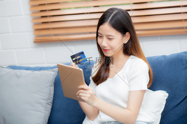 年轻的亚洲女性微笑着拿着信用卡