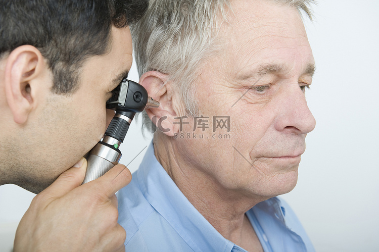 中期成人医生检查老年患者的听力