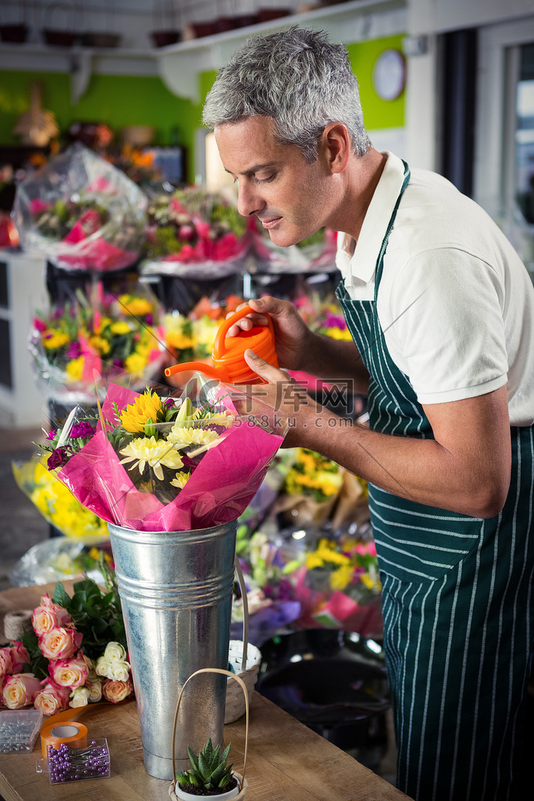 男性花匠用喷壶浇花