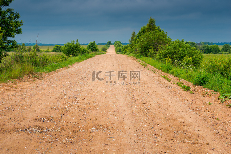 多云天气下田野中乡村土路的景色