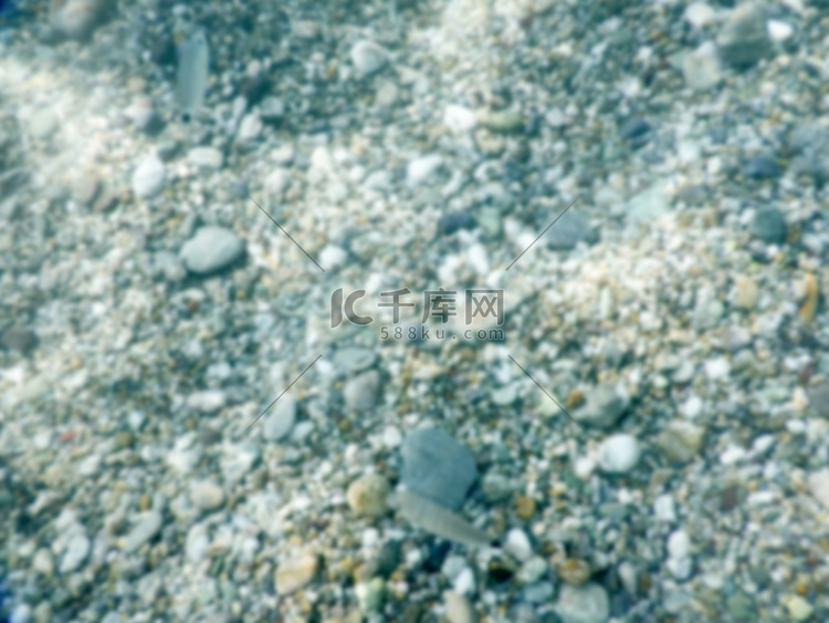 海边水下鹅卵石的散焦背景