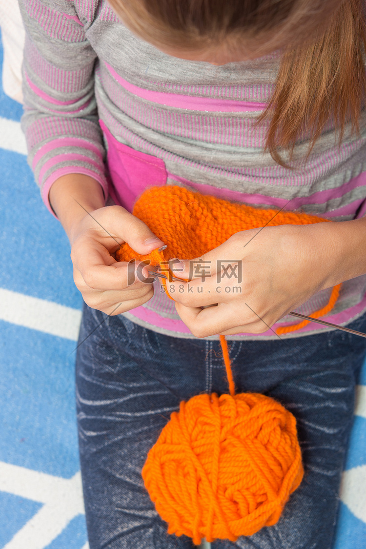 用针围巾橙色线编织的孩子的顶视
