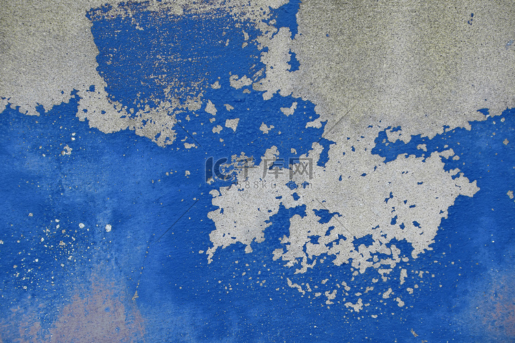 灰色混凝土墙上的旧蓝色油漆片