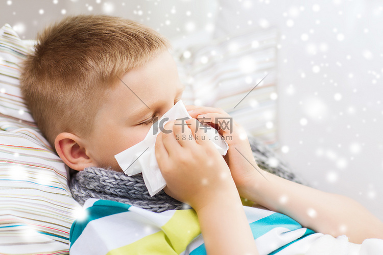 生病的男孩在家里用纸巾擤鼻涕