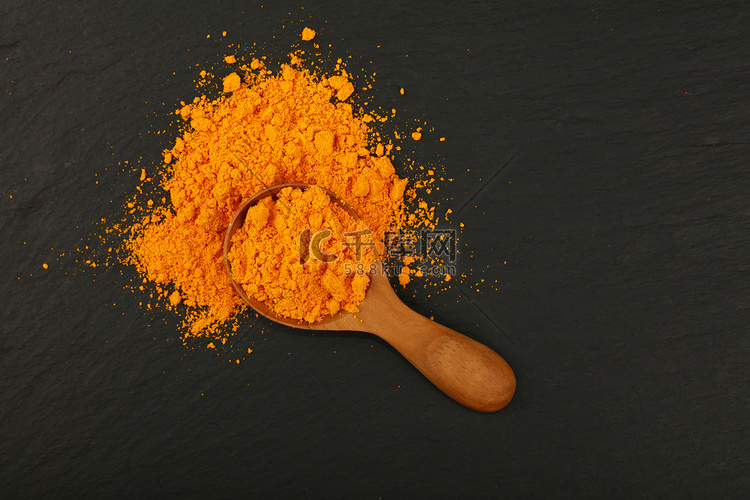 装满黄色姜黄粉的木勺
