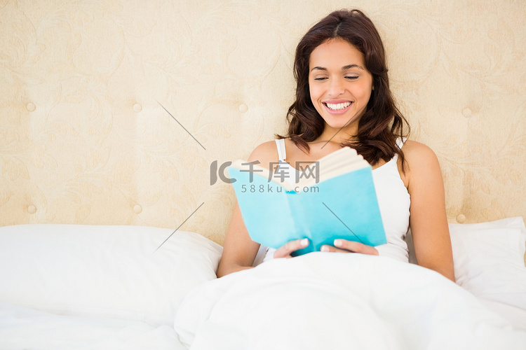 漂亮的女人在床上看书