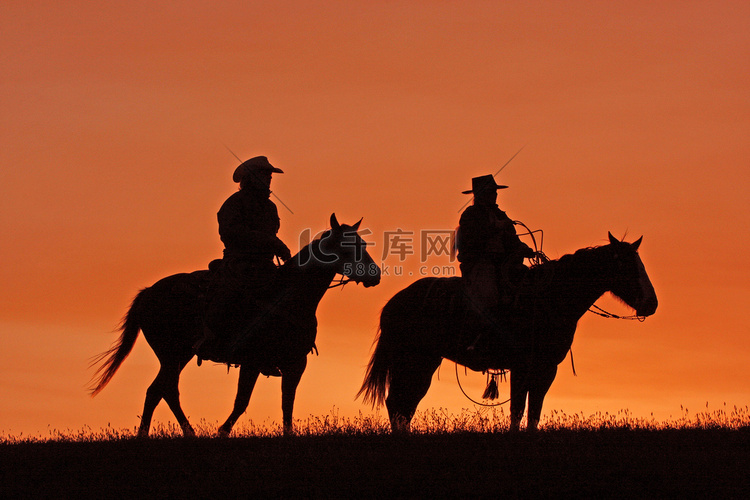 日落时骑在马背上的牛仔剪影