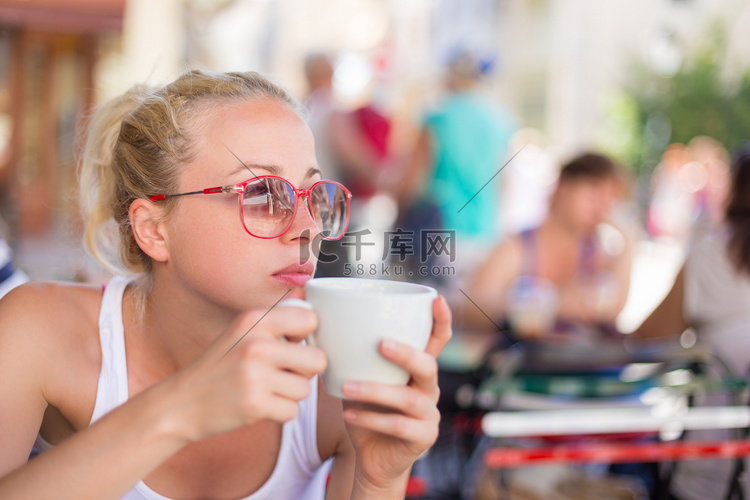 女人在街上喝咖啡。
