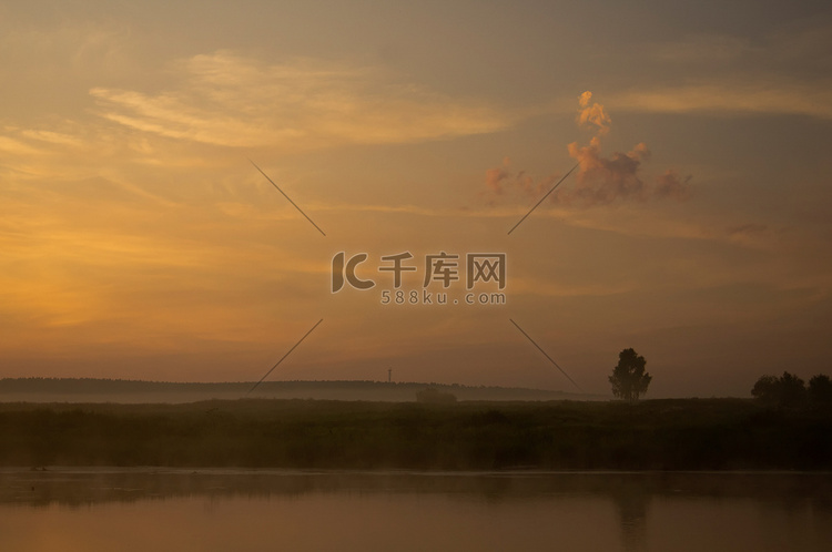 夕阳下的湖水，沿岸的草地和树木