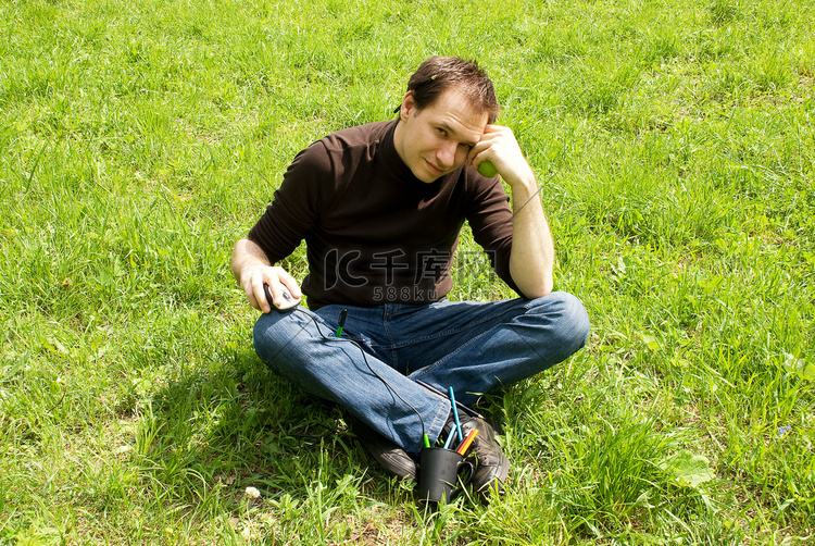坐在绿草地上的男人