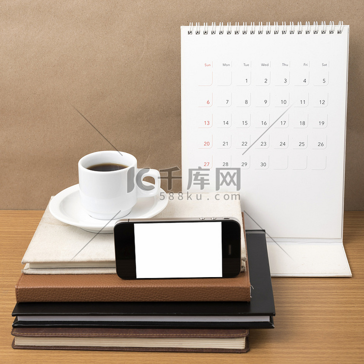 咖啡、电话、一摞书和日历