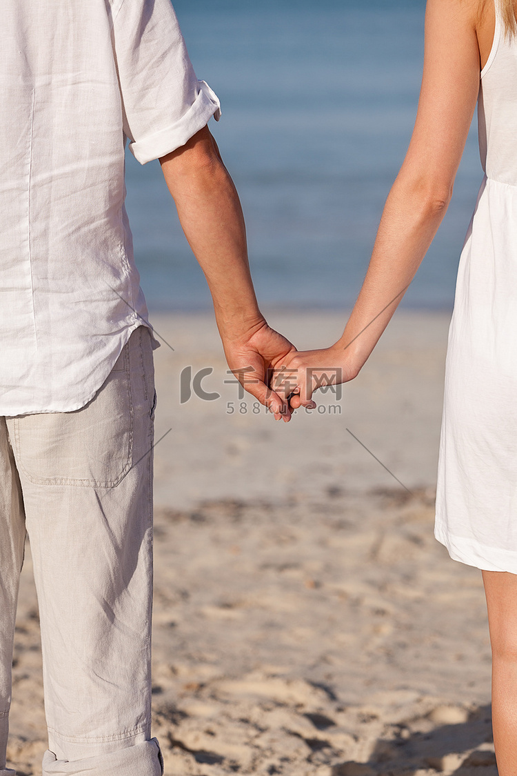 夏日沙滩上牵手相爱的情侣
