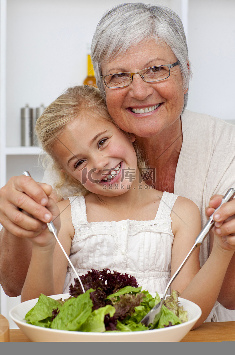 快乐的祖母和孙女一起吃沙拉