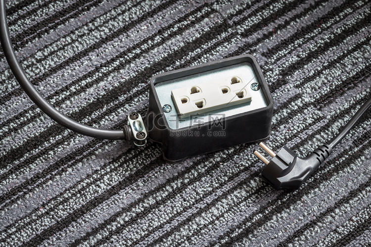 地毯地板上带电源插头电缆的电插