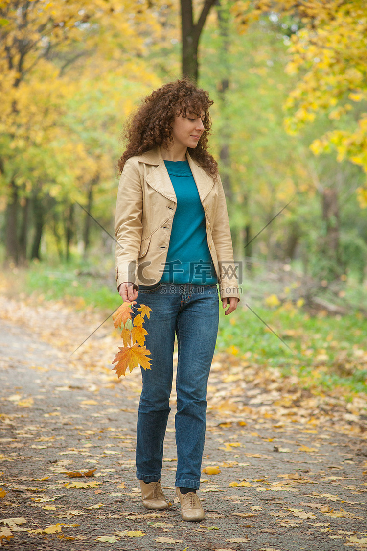 美丽的女孩走在秋天的公园