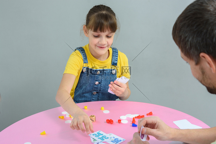 女孩和爸爸玩纸牌棋盘游戏