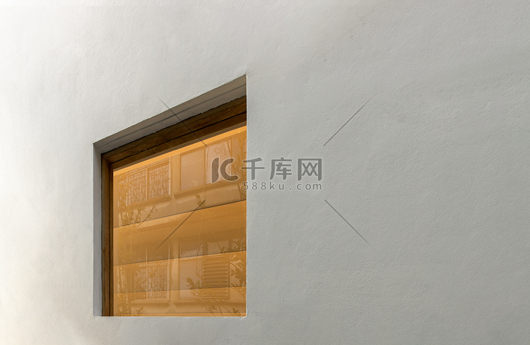 窗户房子反映在白色墙壁上的玻璃