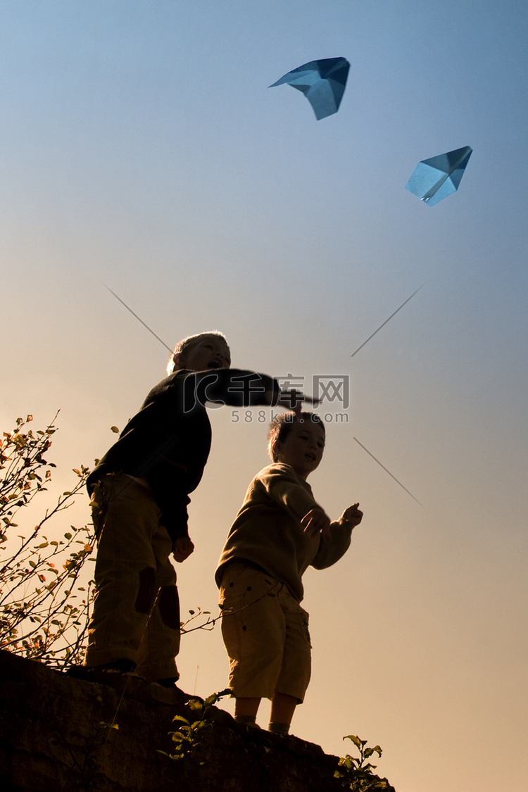 两个孩子在玩纸飞机