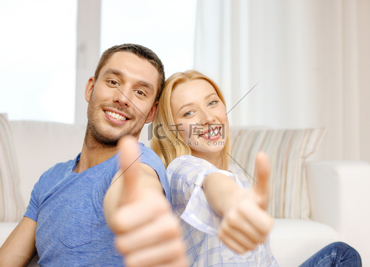 微笑的幸福夫妇在家里竖起大拇指