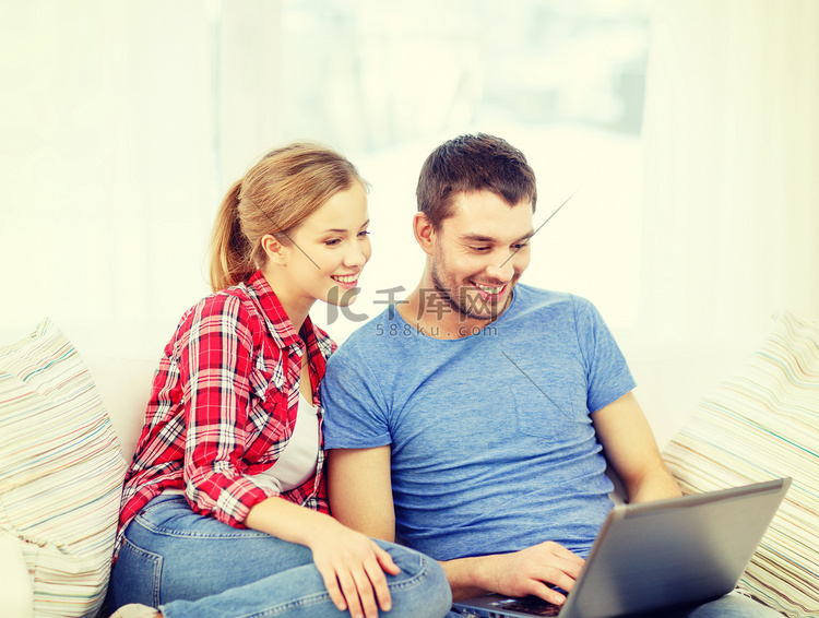 微笑的夫妇在家里用笔记本电脑
