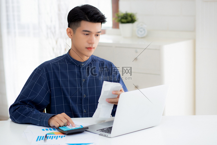年轻的亚洲男子用家里的办公桌上