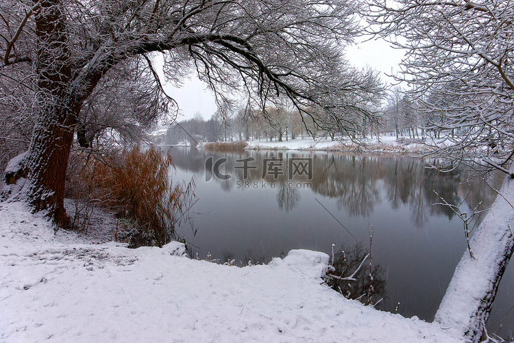 多雪的冬季景观与宁静的河流或湖