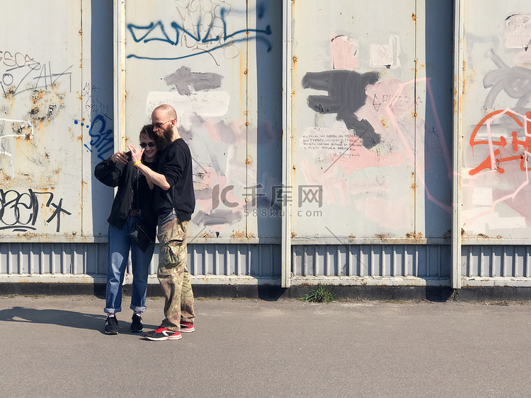 幸福的情侣在墙上的涂鸦上拍照