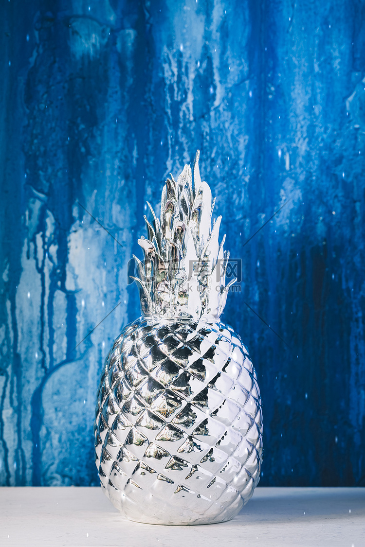 蓝漆墙背景上的人造银菠萝