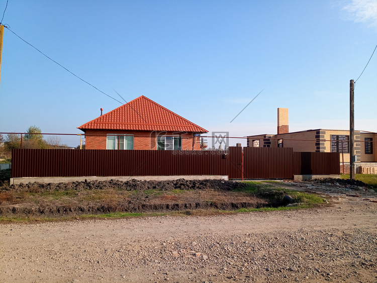 有橙色屋顶和棕色栅栏的新房子。