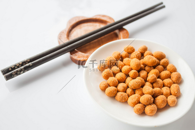 白桌上的辣花生小吃和筷子
