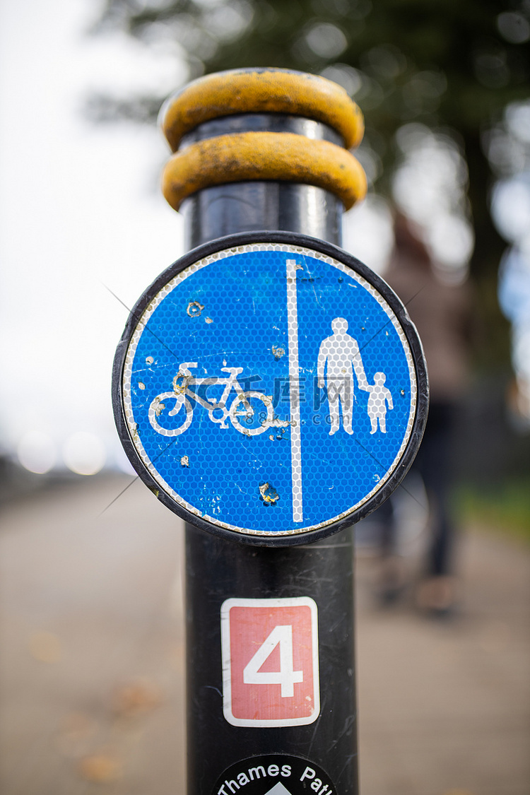 杆子上的蓝色标志指示行人和骑自