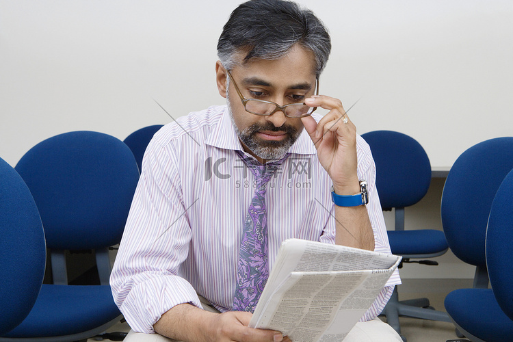 一位印度商人在培训室看报纸