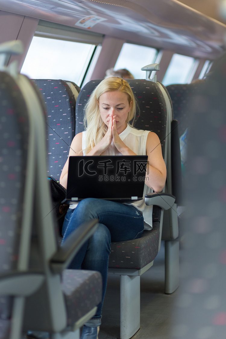 坐火车旅行的女人在笔记本电脑上