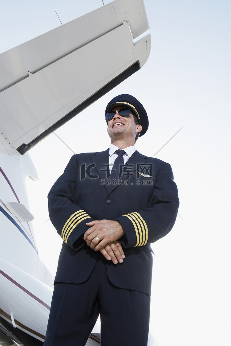 一位身穿制服、双手紧握站在飞机