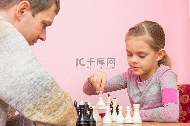 女孩在与教练下棋时做出下一步