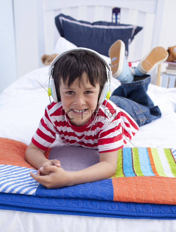 戴耳机躺在床上听音乐的男孩肖像