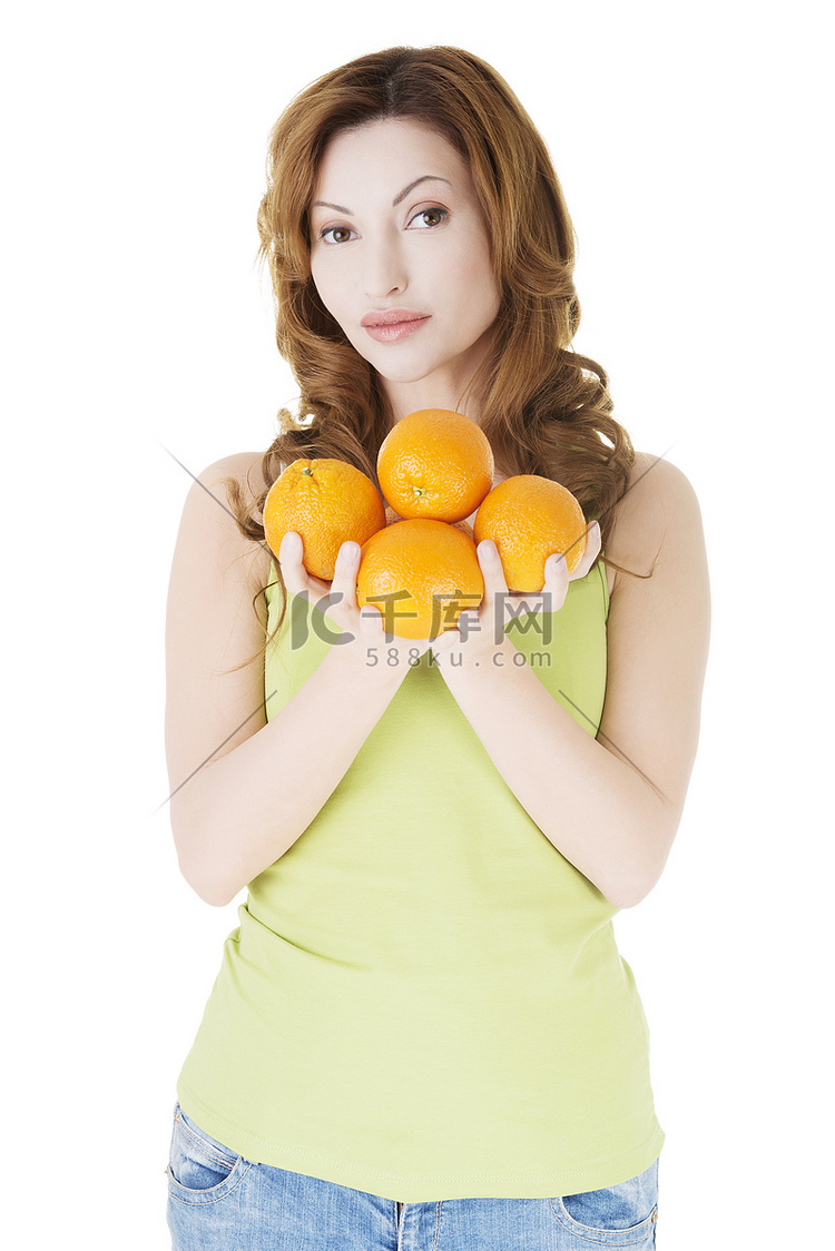 拿着橙色水果的快乐女人